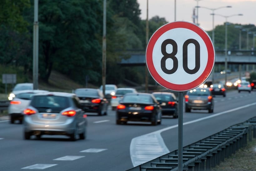 Speed limit sign with a traffic in the background
